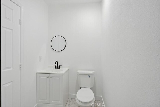 44242 Benald St, Lancaster, CA 93535 - half bathroom featuring vanity, toilet, and baseboards