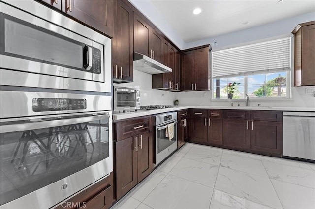 1600 Liv Ct, Redlands, CA 92374 - kitchen with stainless steel appliances, extractor fan, light marble finish floors, light countertops, and a sink