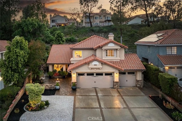 25009 Wintergreen Ct, Stevenson Ranch, CA 91381 - view of front of home featuring concrete driveway, a tiled roof, stucco siding, a chimney, and stone siding