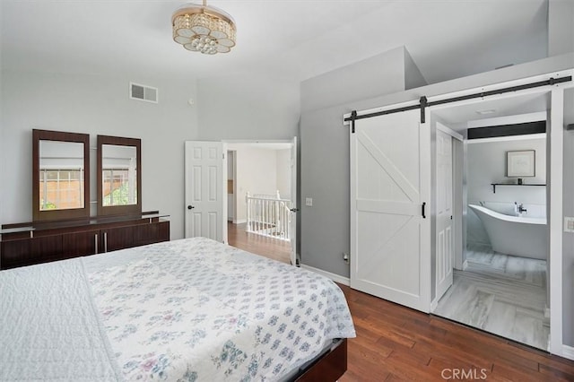 25009 Wintergreen Ct, Stevenson Ranch, CA 91381 - bedroom featuring a barn door, wood finished floors, and lofted ceiling