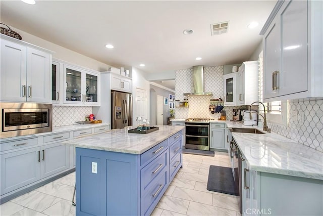 543 Garden Ave, Pomona, CA 91767 - kitchen with stainless steel appliances, wall chimney exhaust hood, light marble finish flooring, decorative backsplash, and recessed lighting