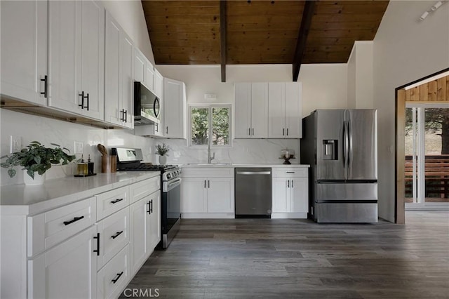 27947 St Bernard Ln, Lake Arrowhead, CA 92352 - kitchen featuring appliances with stainless steel finishes, wood ceiling with exposed beams, a sink, dark wood-type flooring, and tasteful backsplash