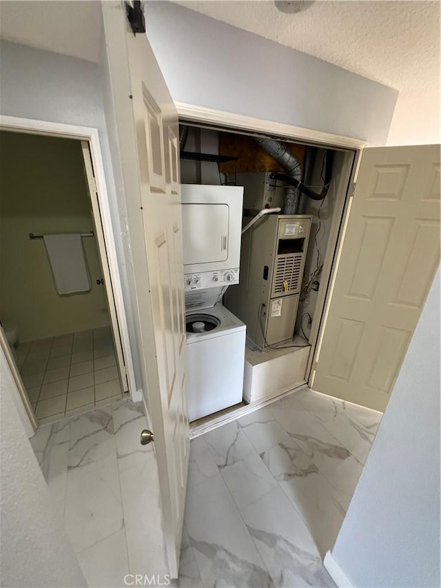 21212 Camelia Unit 46, Lake Forest, CA 92630 - laundry room featuring estacked washer and dryer and light marble finish floors