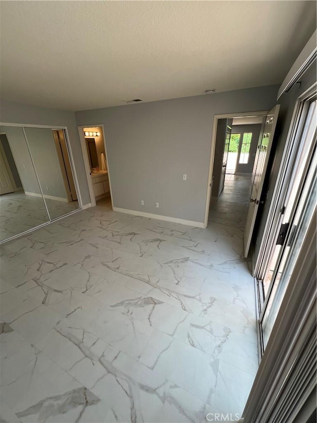21212 Camelia Unit 46, Lake Forest, CA 92630 - unfurnished bedroom featuring baseboards, light marble finish floors, and a textured ceiling
