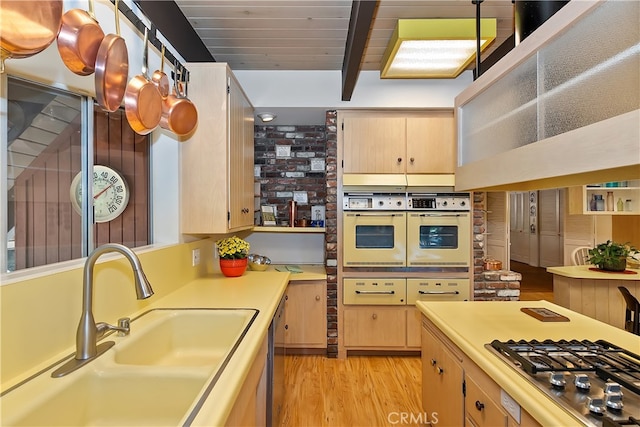 27280 Peninsula Dr, Lake Arrowhead, CA 92352 - kitchen featuring appliances with stainless steel finishes, a sink, light wood-style flooring, light countertops, and beam ceiling