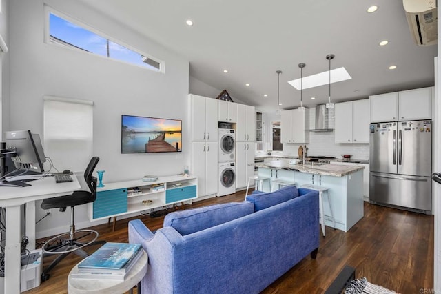 1918 S Freeman St, Oceanside, CA 92054 - living room with stacked washer / dryer, dark wood-style flooring, recessed lighting, high vaulted ceiling, and a skylight