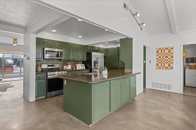 1918 S Freeman St, Oceanside, CA 92054 - kitchen with green cabinetry, stainless steel appliances, concrete floors, dark countertops, and decorative backsplash