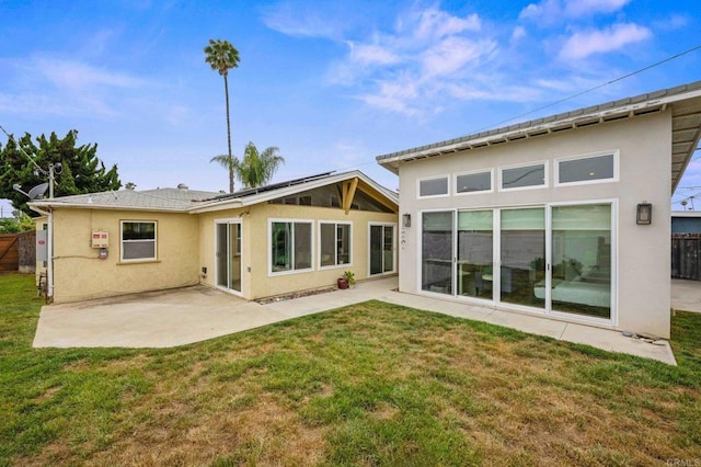 1918 S Freeman St, Oceanside, CA 92054 - rear view of property featuring stucco siding, roof mounted solar panels, and a patio area