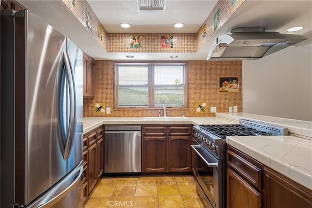 45740 Verba Santa Dr, Palm Desert, CA 92260 - kitchen featuring stainless steel appliances, decorative backsplash, tile counters, a textured ceiling, and recessed lighting