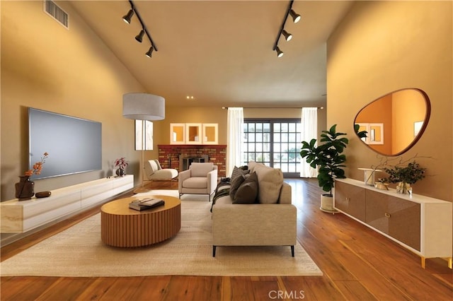 4163 Alma Ct, Chino, CA 91710 - living room featuring rail lighting, high vaulted ceiling, wood-type flooring, and a fireplace