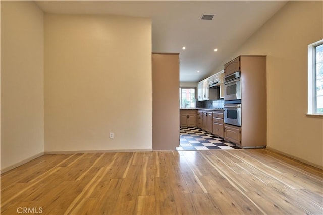 4163 Alma Ct, Chino, CA 91710 - kitchen with double oven, light wood-style flooring, decorative backsplash, vaulted ceiling, and range hood
