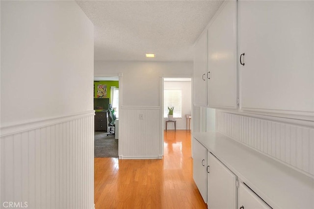 22784 Wren St, Grand Terrace, CA 92313 - hallway with a wainscoted wall, light wood-type flooring, and a textured ceiling