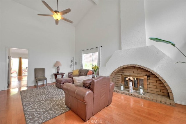 22784 Wren St, Grand Terrace, CA 92313 - living room featuring high vaulted ceiling, ceiling fan, wood finished floors, a fireplace, and beam ceiling