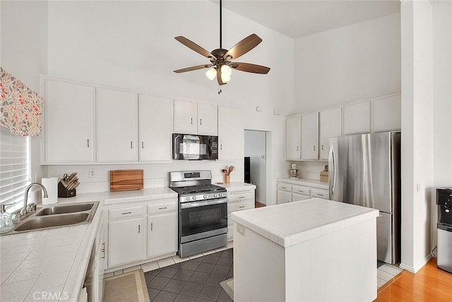 22784 Wren St, Grand Terrace, CA 92313 - kitchen featuring appliances with stainless steel finishes, high vaulted ceiling, tile counters, a sink, and ceiling fan