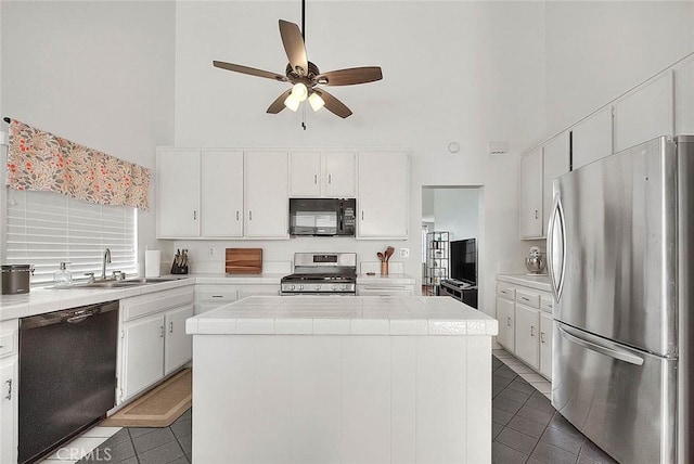 22784 Wren St, Grand Terrace, CA 92313 - kitchen featuring black appliances, a high ceiling, tile countertops, a kitchen island, and tile patterned flooring