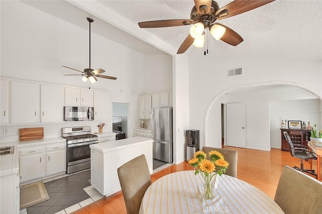 22784 Wren St, Grand Terrace, CA 92313 - dining room with ceiling fan, a textured ceiling, arched walkways, high vaulted ceiling, and light wood-style floors