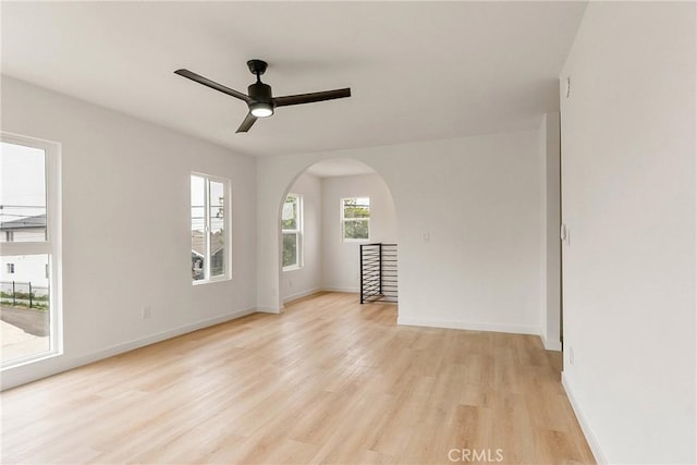 1209 W 40th Pl, Los Angeles, CA 90037 - spare room featuring arched walkways, light wood-style flooring, a ceiling fan, and baseboards