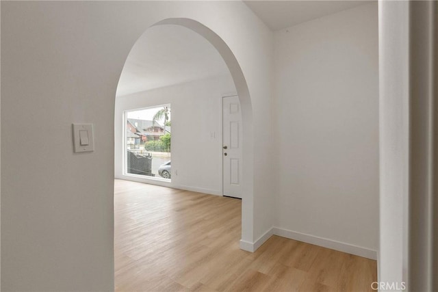 1209 W 40th Pl, Los Angeles, CA 90037 - hall featuring arched walkways, light wood finished floors, and baseboards