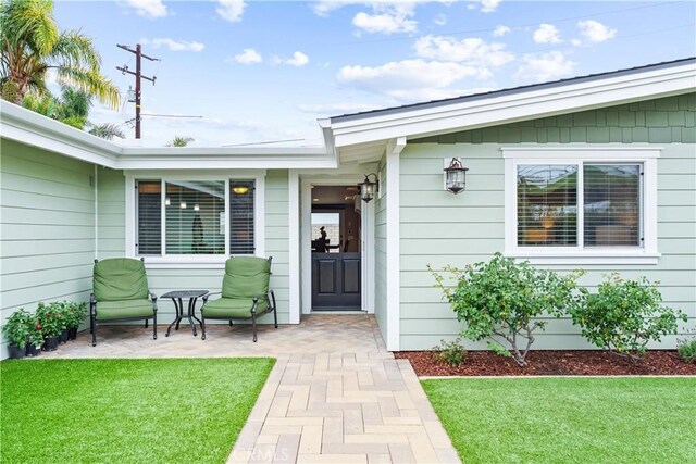 249 Loyola Rd, Costa Mesa, CA 92626 - doorway to property featuring a lawn and a patio