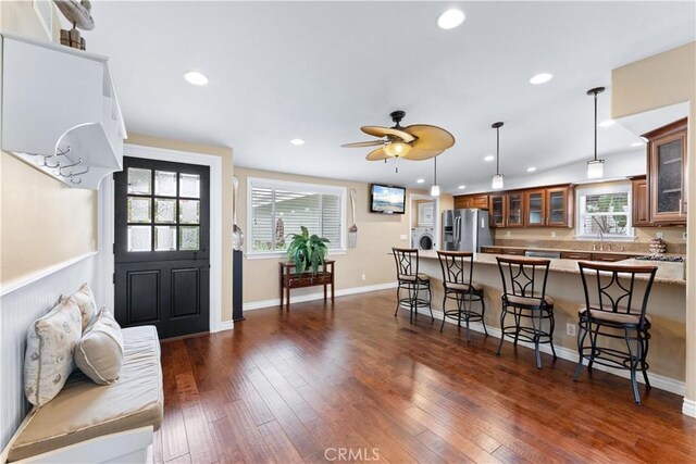 249 Loyola Rd, Costa Mesa, CA 92626 - kitchen with stainless steel fridge with ice dispenser, brown cabinets, a breakfast bar area, a peninsula, and healthy amount of natural light