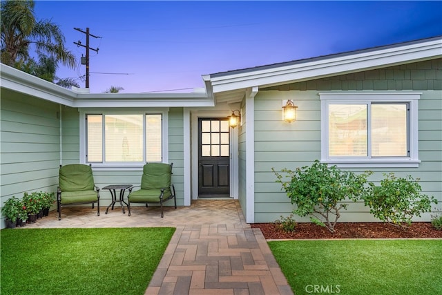 249 Loyola Rd, Costa Mesa, CA 92626 - exterior entry at dusk featuring a yard and a patio