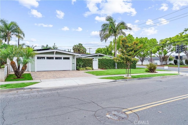 249 Loyola Rd, Costa Mesa, CA 92626 - view of front of house featuring roof mounted solar panels, driveway, a garage, and a front yard