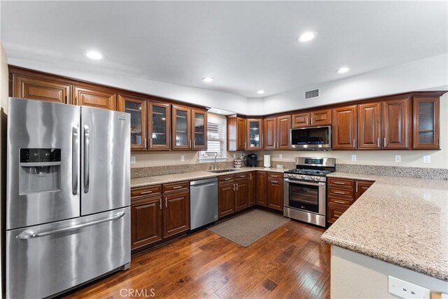 249 Loyola Rd, Costa Mesa, CA 92626 - kitchen featuring stainless steel appliances, dark wood finished floors, a sink, glass insert cabinets, and recessed lighting