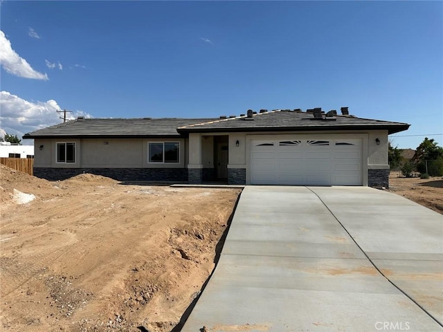 21109 Sioux Rd, Apple Valley, CA 92308 - view of front of property with stone siding, an attached garage, stucco siding, and concrete driveway