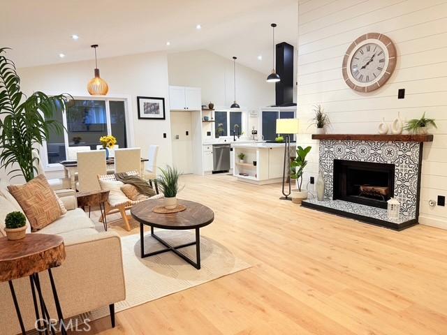 1254 W Van Koevering St, Rialto, CA 92376 - living area featuring light wood-style flooring, high vaulted ceiling, and a tile fireplace