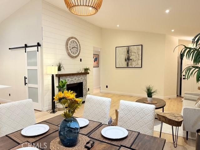 1254 W Van Koevering St, Rialto, CA 92376 - living area with lofted ceiling, light wood finished floors, a barn door, recessed lighting, and a tile fireplace
