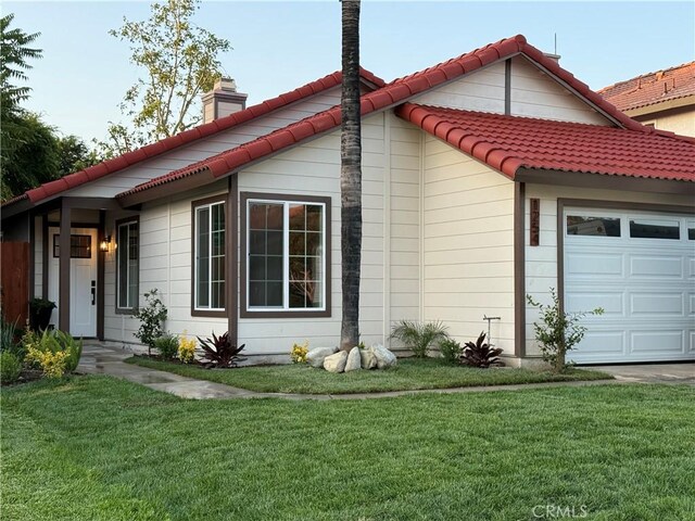 1254 W Van Koevering St, Rialto, CA 92376 - view of front of home featuring a garage, a front lawn, and a chimney