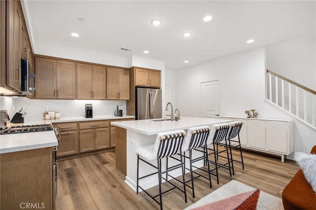 39376 Corvina Ln, Temecula, CA 92591 - kitchen with stainless steel appliances, a breakfast bar area, dark wood-type flooring, recessed lighting, and a sink