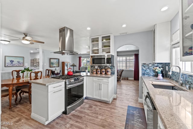 1350 Elder St, Oxnard, CA 93036 - kitchen featuring stainless steel appliances, island exhaust hood, a peninsula, ceiling fan, and backsplash