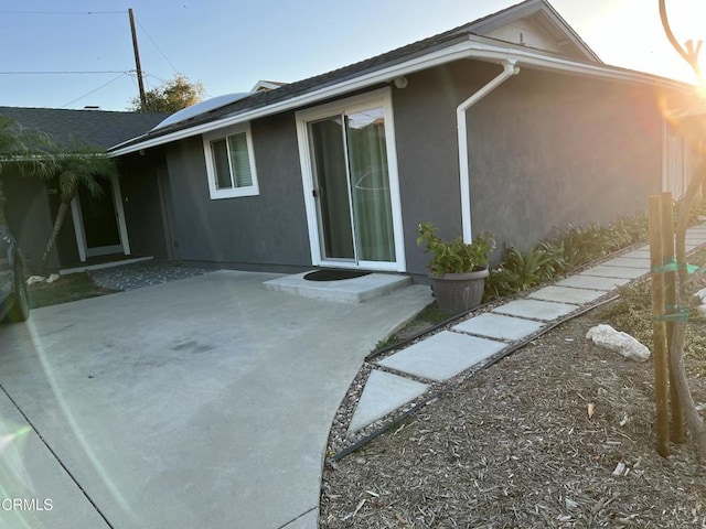 1350 Elder St, Oxnard, CA 93036 - view of side of home featuring stucco siding, a patio, and solar panels