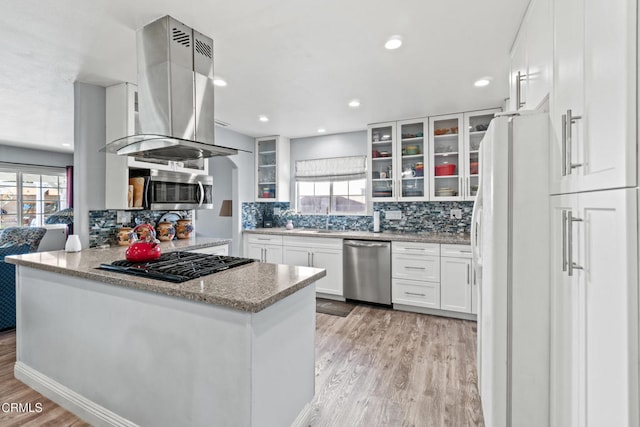1350 Elder St, Oxnard, CA 93036 - kitchen featuring appliances with stainless steel finishes, island exhaust hood, light wood-style floors, backsplash, and white cabinets