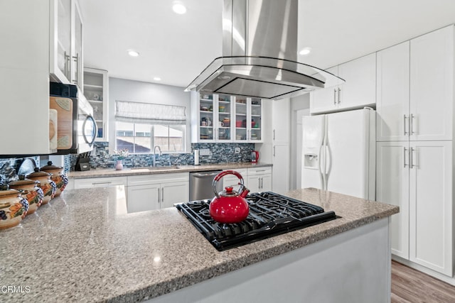 1350 Elder St, Oxnard, CA 93036 - kitchen featuring island range hood, appliances with stainless steel finishes, glass insert cabinets, white cabinetry, and light stone countertops