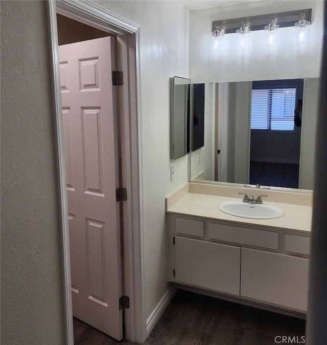 27971 Sarabande Ln Unit 230, Canyon Country, CA 91387 - bathroom with wood finished floors, vanity, baseboards, and a textured wall