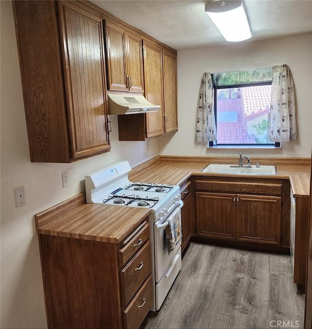 27971 Sarabande Ln Unit 230, Canyon Country, CA 91387 - kitchen with gas range gas stove, under cabinet range hood, a sink, wood finished floors, and butcher block counters