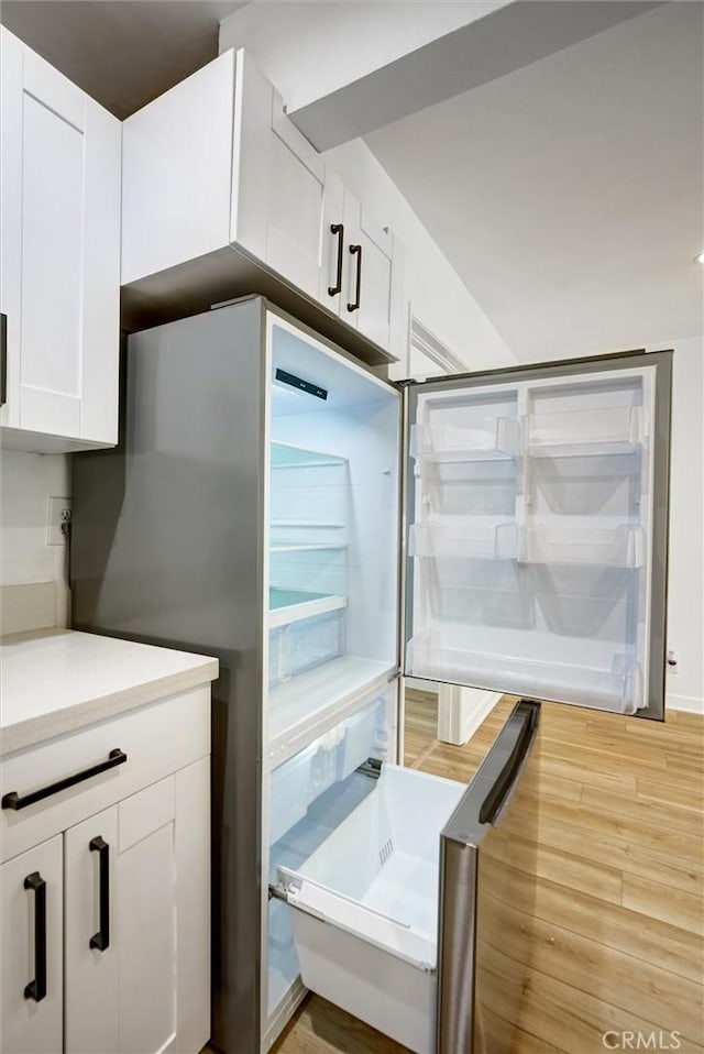23391 Park Sorrento Unit 62, Calabasas, CA 91302 - kitchen featuring light wood-type flooring, white cabinetry, light countertops, and high end refrigerator