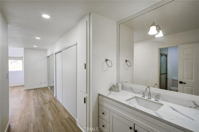 23391 Park Sorrento Unit 62, Calabasas, CA 91302 - bathroom with vanity, wood finished floors, toilet, recessed lighting, and a shower with shower door