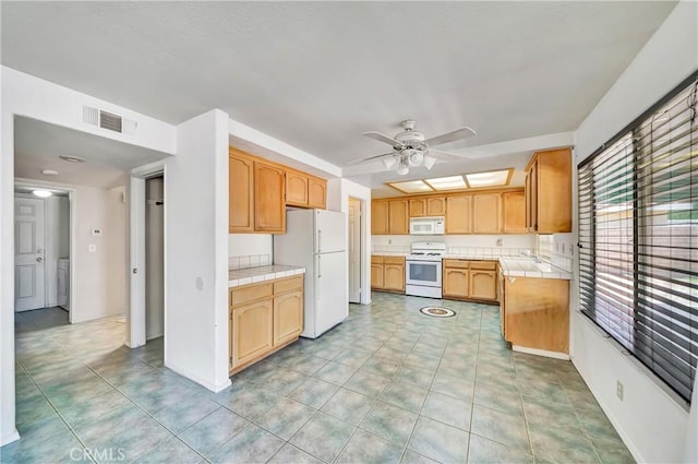 3065 Sabre St, Rosamond, CA 93560 - kitchen featuring white appliances, tile countertops, a ceiling fan, and a sink