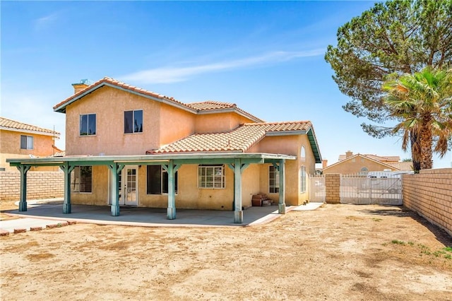 3065 Sabre St, Rosamond, CA 93560 - back of house with a gate, a patio area, stucco siding, and a tiled roof