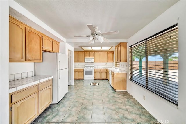 3065 Sabre St, Rosamond, CA 93560 - kitchen featuring white appliances, tile countertops, ceiling fan, and light brown cabinets
