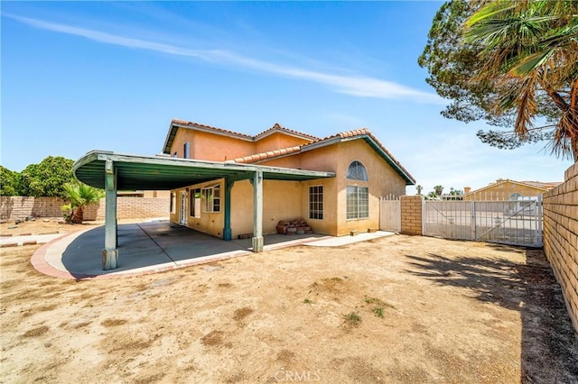 3065 Sabre St, Rosamond, CA 93560 - back of property featuring stucco siding, a fenced backyard, a tiled roof, and a patio