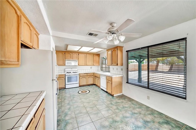 3065 Sabre St, Rosamond, CA 93560 - kitchen featuring white appliances, light brown cabinets, light countertops, a ceiling fan, and light tile patterned floors