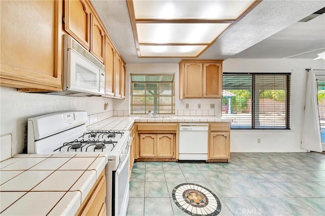 3065 Sabre St, Rosamond, CA 93560 - kitchen featuring white appliances, tile counters, a sink, light brown cabinetry, and light tile patterned floors