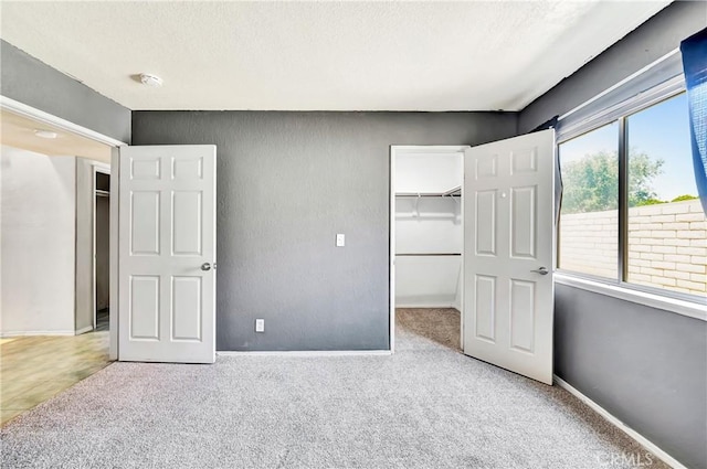 3065 Sabre St, Rosamond, CA 93560 - unfurnished bedroom featuring carpet floors, a walk in closet, a closet, baseboards, and a textured ceiling