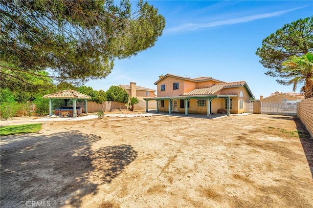 3065 Sabre St, Rosamond, CA 93560 - rear view of house with a gazebo, a fenced backyard, a hot tub, and a tile roof