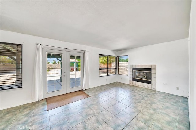 3065 Sabre St, Rosamond, CA 93560 - unfurnished living room with french doors, a tiled fireplace, and tile patterned floors