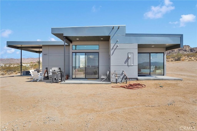 64177 Sullivan Rd, Joshua Tree, CA 92252 - rear view of property with stucco siding and a mountain view